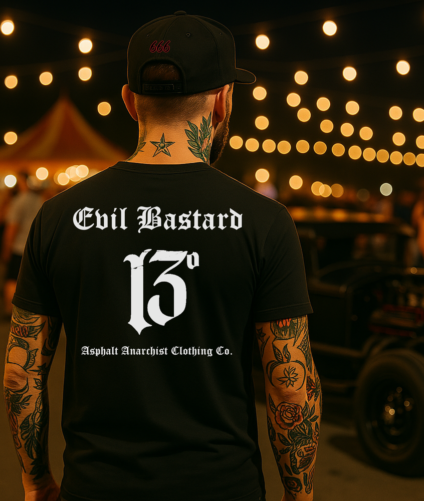 
                  
                    Back view of black soft-style “Evil Bastard” tee in bold Old English font with a distressed number 13, worn by a rugged gearhead at a moonlit carnival car show. He’s eyeing a slammed rat rod under neon lights and string bulbs, surrounded by chrome, grease, and low-end rumble. By Asphalt Anarchist Clothing Co. This image was generated by AI.
                  
                