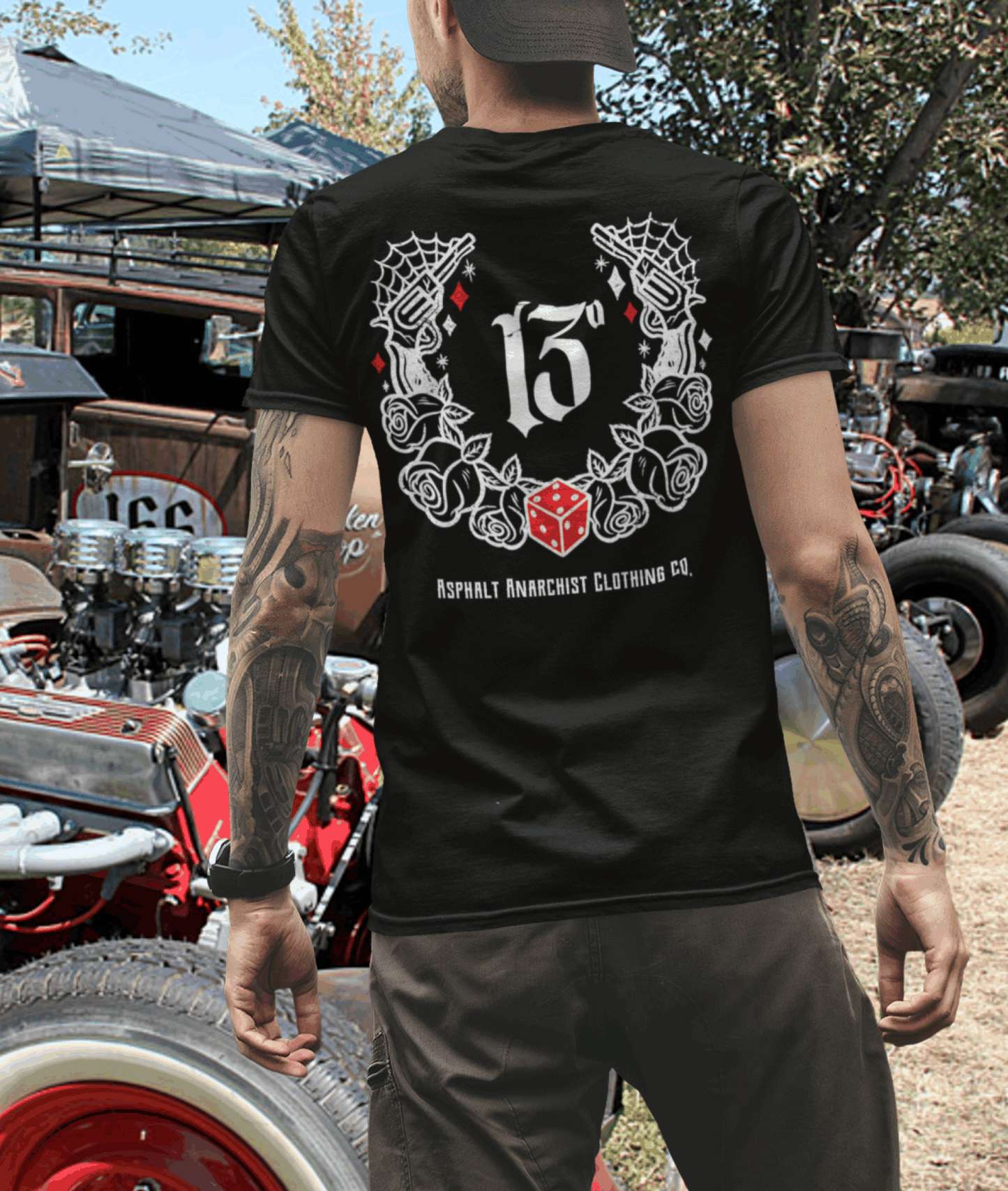 
                  
                    🖤 Tattooed rat rod enthusiast browsing crusty classic rods at a sunlit local car show, sporting the black “Big Iron” Tee by Asphalt Anarchist Clothing Co.—a rebel look topped with cobwebs, dice, pistols, number 13, and roses. Dust, rust, and ink collide in a gritty homage to garage culture and outlaw attitude.
This image was AI-generated to visually represent the scene described.

                  
                